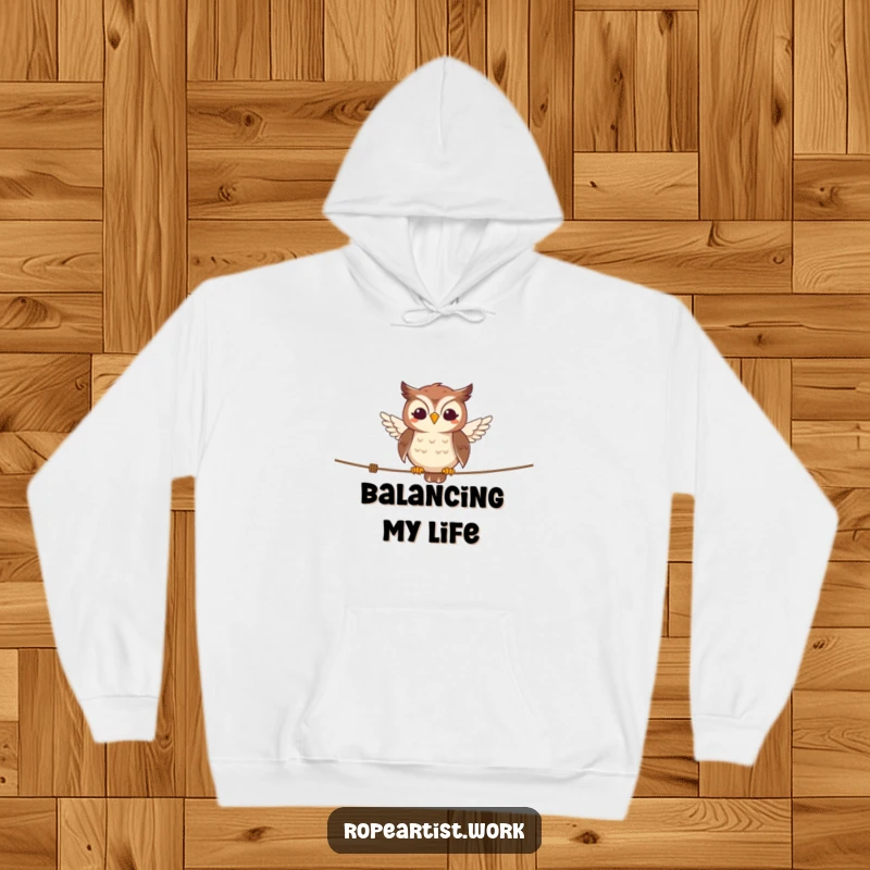 Funny owl hoodie featuring a smiling character balancing on a tightrope, cozy and humorously wise apparel.